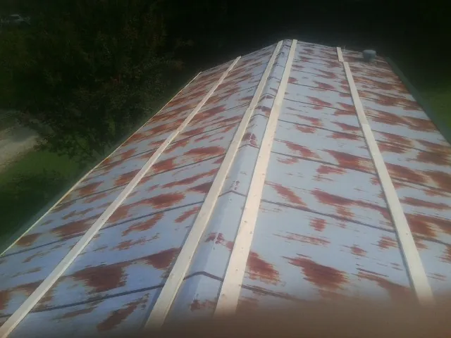 Rusted metal roof panels with new wood purlins before replacement — Storm Damage Roof Repair in Barnstead by Roofing Brothers